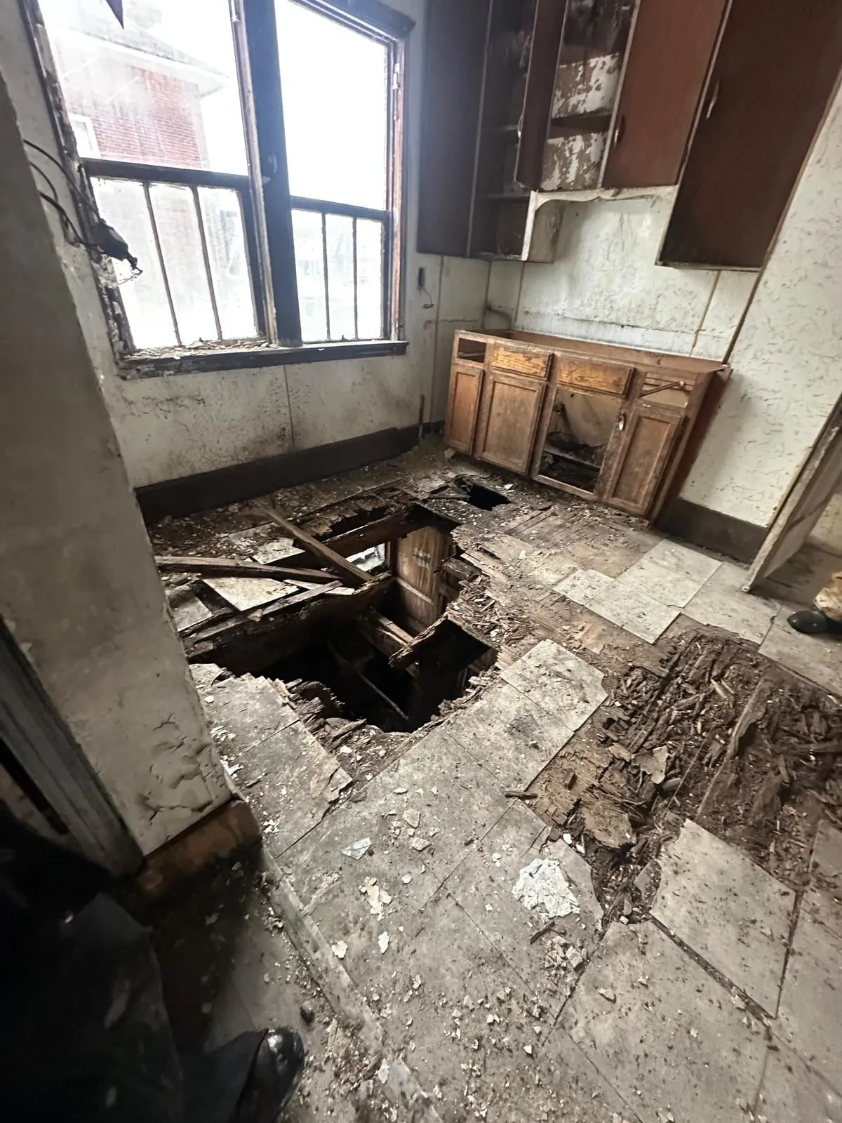 Cocina original destruida, con boquetes en el piso que dejan ver el sótano