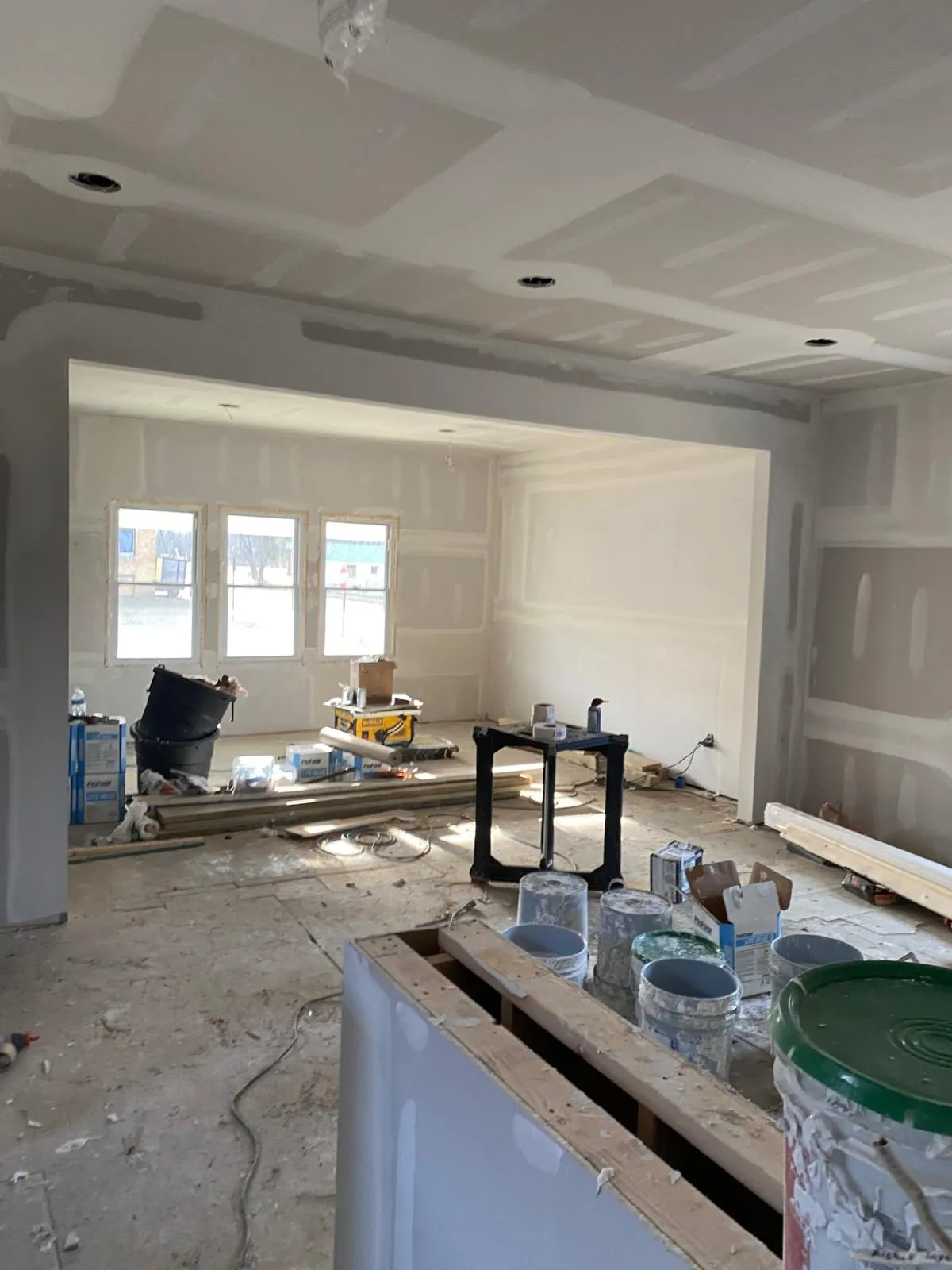 Sala con drywall instalado y encintado, con luces empotradas abiertas